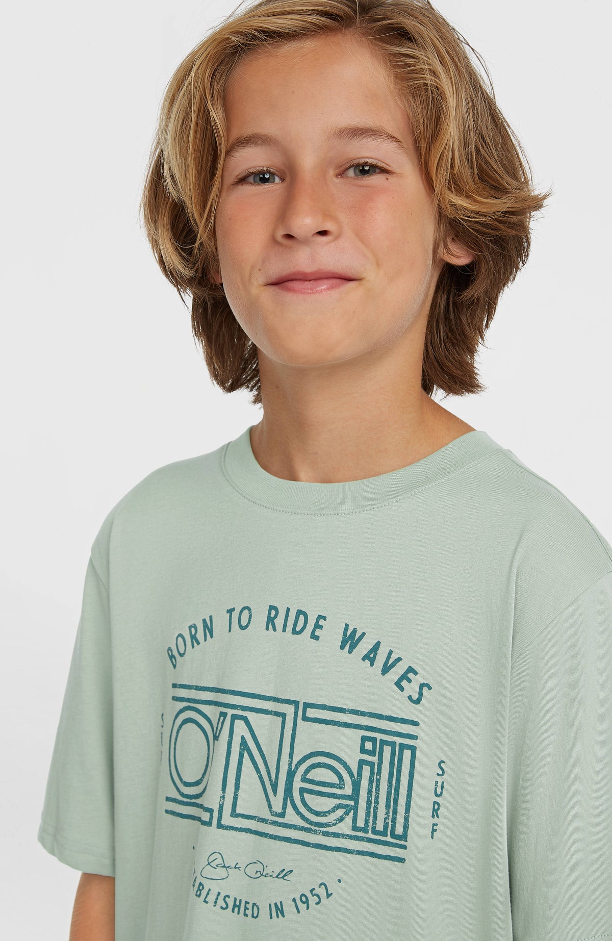 Muir T-Shirt für Jungen, grün mit Logo-Print in Dunkelgrün, Nahaufnahme des Rundhalsausschnitts am Model