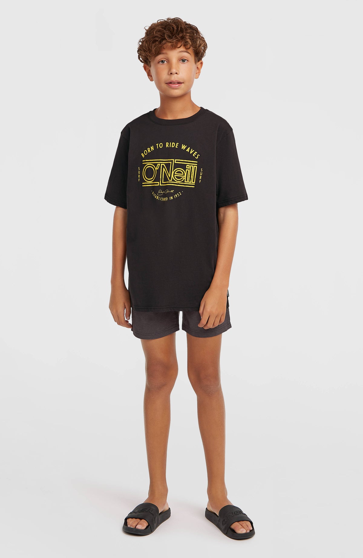 Muir T-Shirt für Jungen, schwarz mit Logo-Print in Gelb, Ganzkörperansicht getragen am Model
