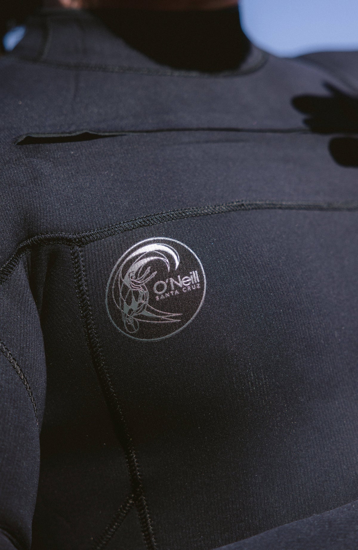 Schwarzer O'Riginals RG8 Neoprenanzug für Herren, Nahaufnahme des runden Logo-Prints auf der Vorderseite
