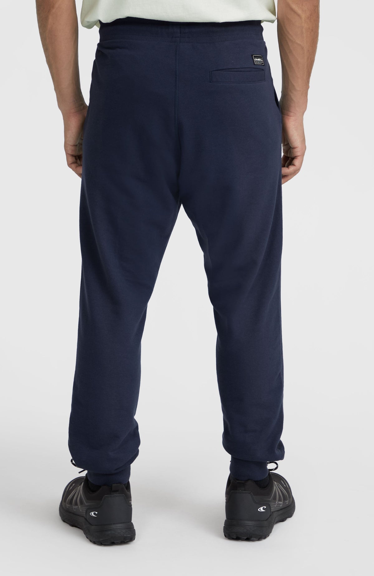 Blaue Logo Jogginghose für Herren, Rückansicht am Model mit Gesäßtasche und Logo-Patch am Bund