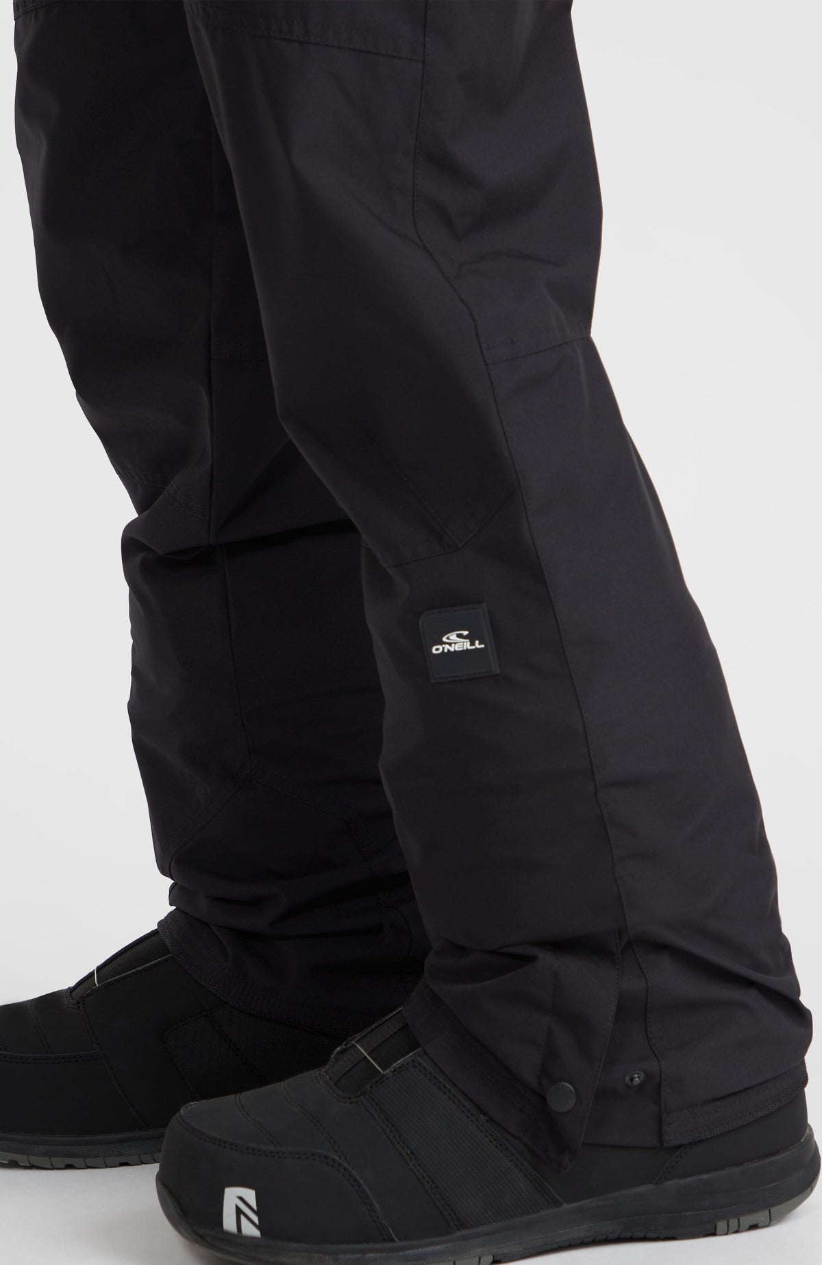 Hammer Regular Skihose, schwarz, Nahaufnahme vom Hosenbein mit Logo-Badge am Model