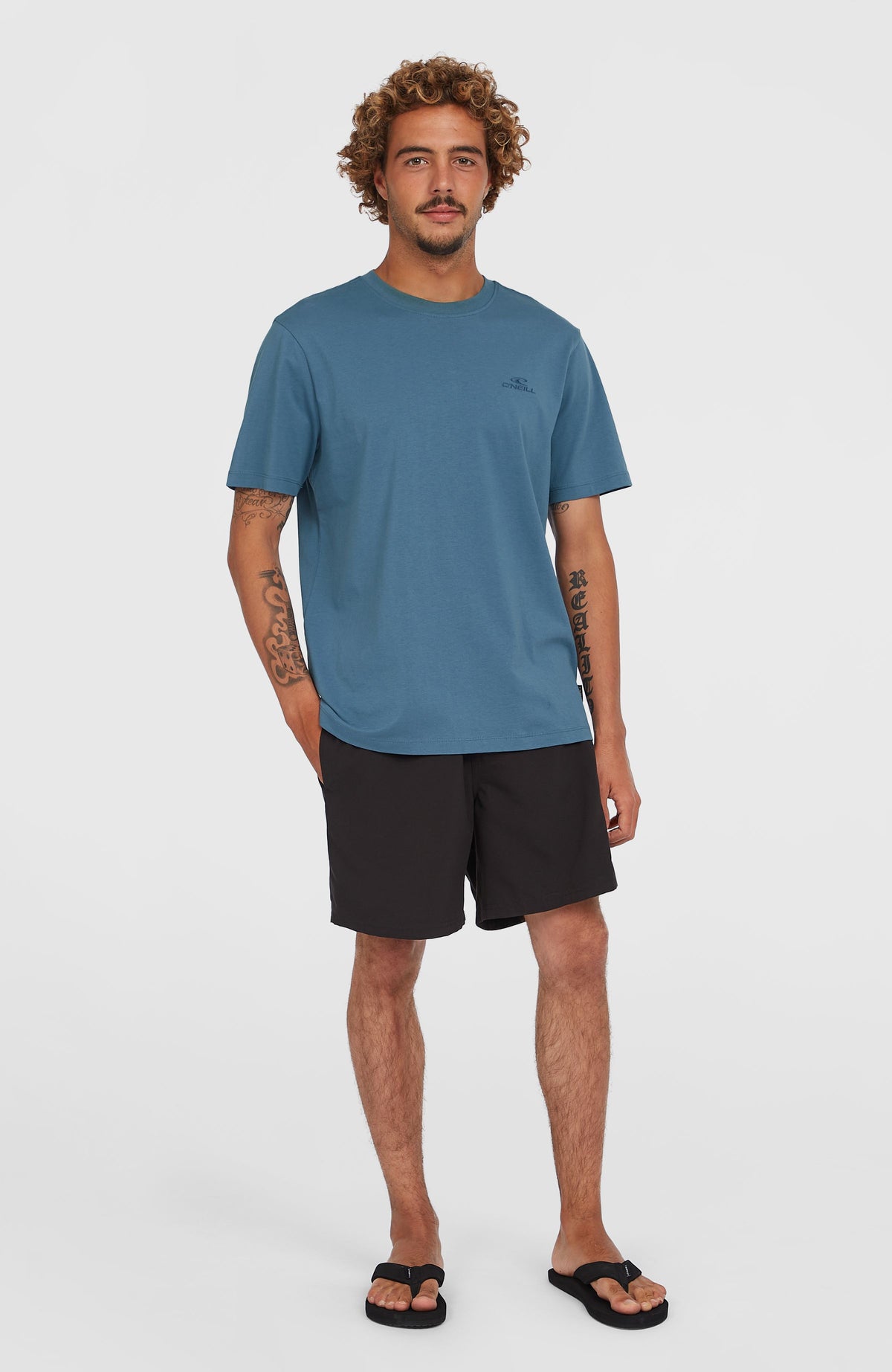 Cali 16'' Badehose für Herren, schwarz, Ganzkörperansicht am Model von vorne, kombiniert mit blauem T-Shirt