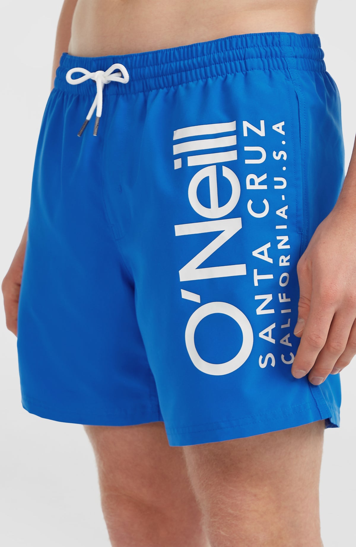 Nahaufnahme von elastischem Bund, Kordelzug und Logo-Print der blauen Original Cali 16'' Badehose am Model