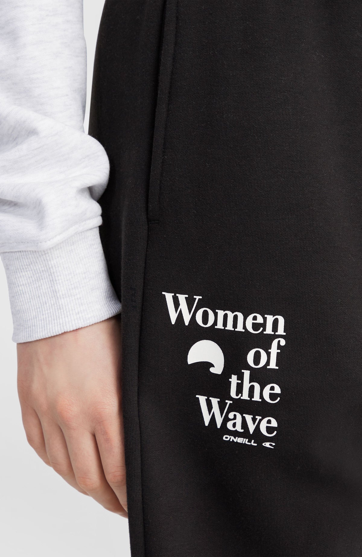 Nahaufnahme des weißen Logo-Prints der schwarzen Women of the Wave Jogginghose