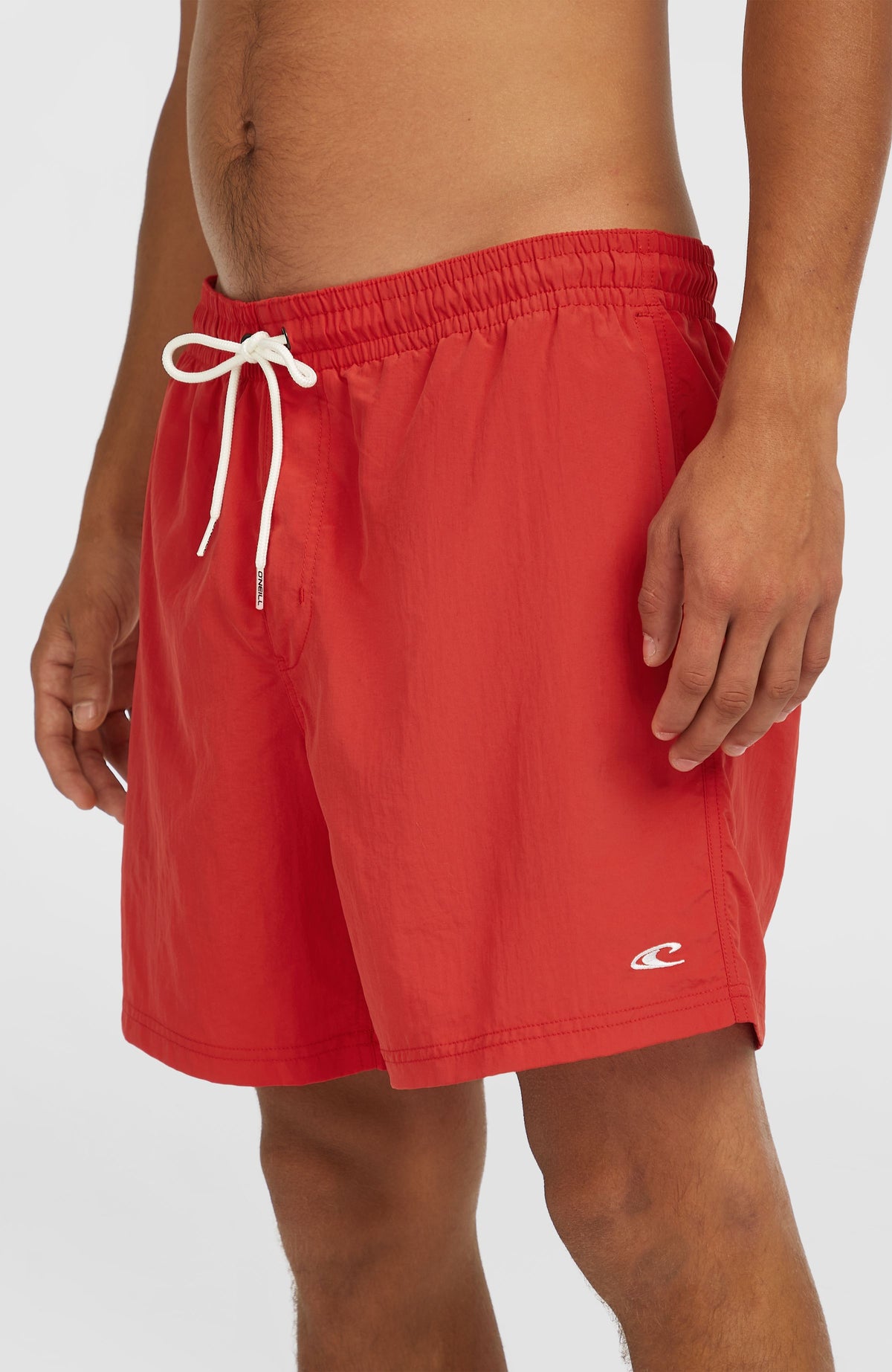 Vert 16" Badehose für Herren, rot, Halbprofil am Model, kleines Logo am linken Hosenbein