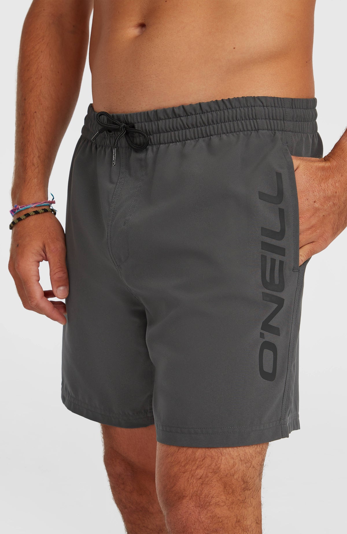 Logo 16" Badehose für Herren, grau, Nahaufnahme am Model mit vertikalem Logo-Print am Hosenbein