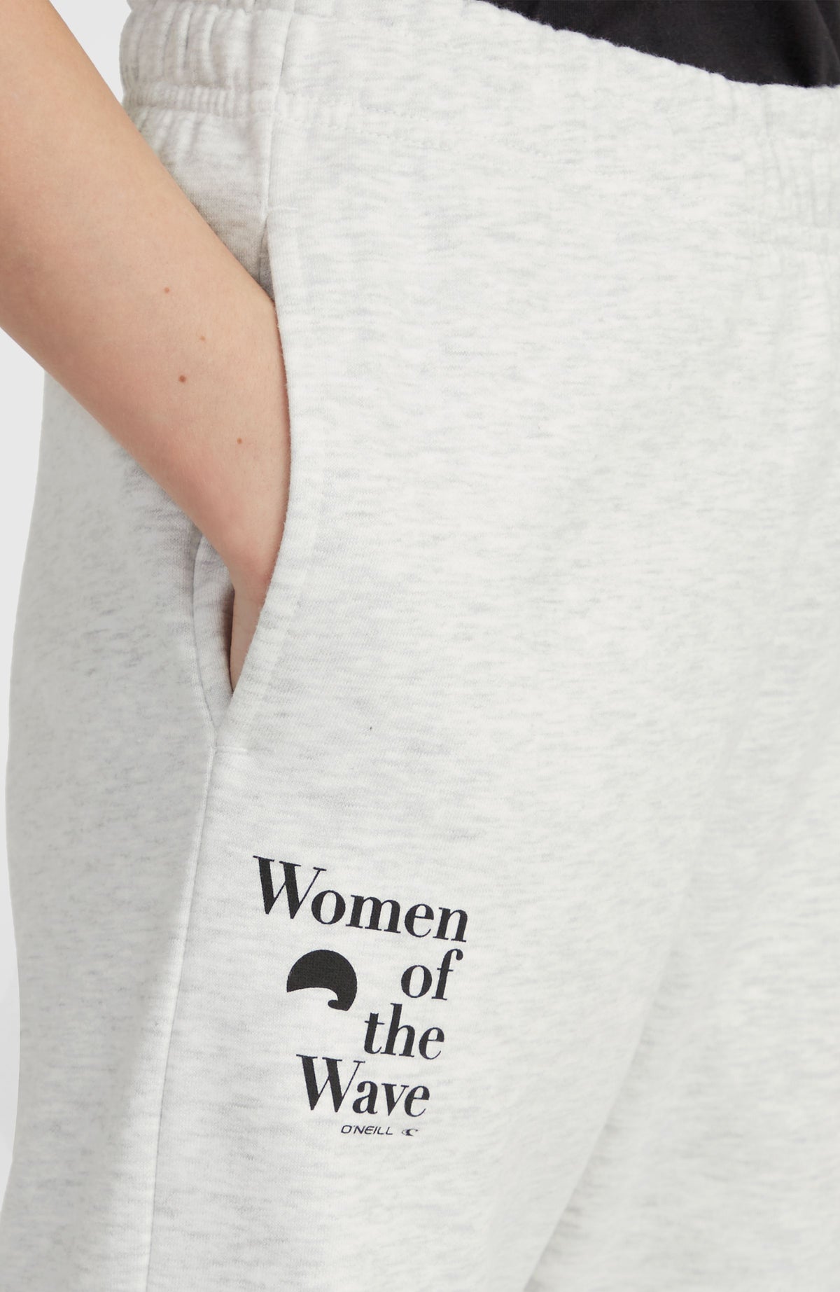 Women of the Wave Jogginghose, weiß mit Logo-Print in Schwarz, Nahaufnahme der Seitentasche am Model